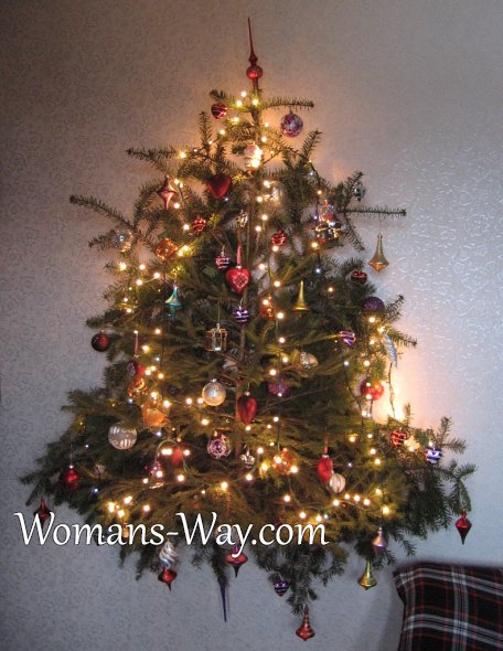 Настенная елка из живых веток подсвеченная новогодней гирляндой